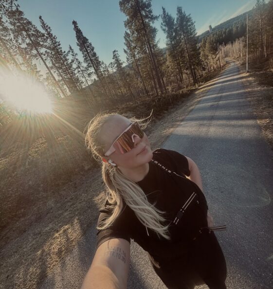 Tjej med träningskläder och sportglasögon i solen efter springtur