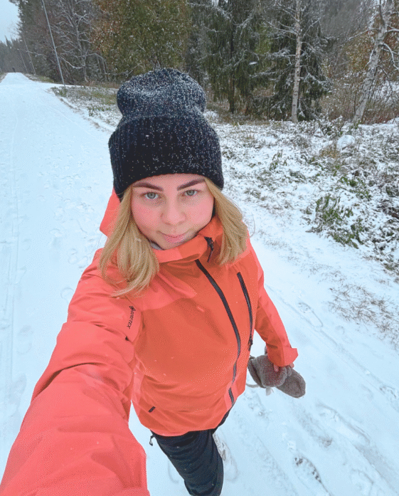 Tjej ute och prommenerar i snötäckt landskap